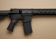 Side view of a black AR-10 rifle on a neutral background